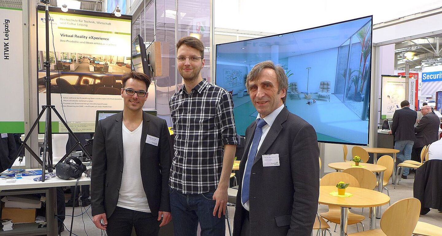 Zwei Studierende und Prof. Hänßgen stehen vor dem Messestand der HTWK Leipzig bei der CeBIT in Hannover