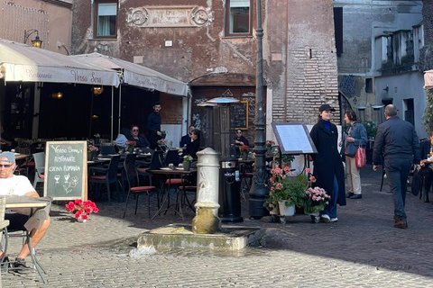 Wohnhäuser mit engen Gassen und einem Café, in dem mehrere Menschen entspannt sitzen.