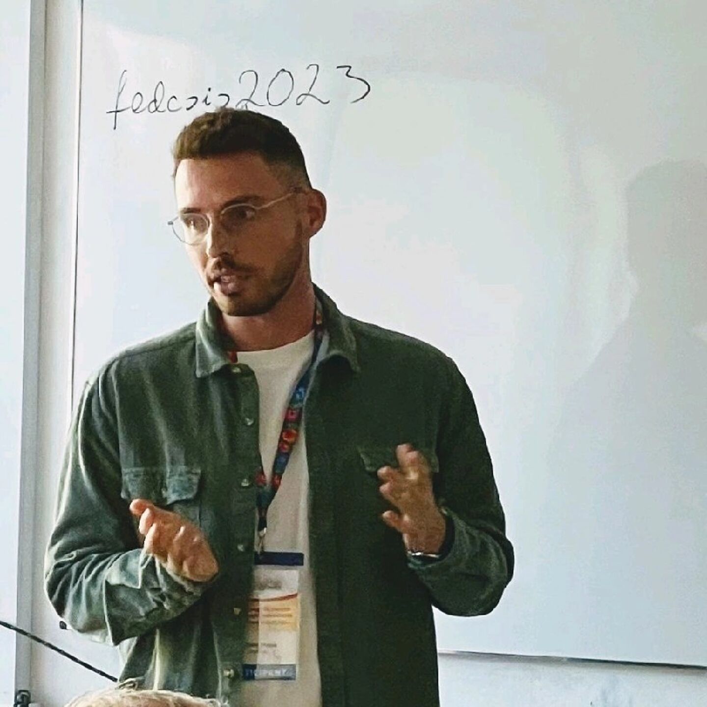 Philippe Krajsic vor einem Whiteboard und mit seinen Händen erklärend gestikuliert