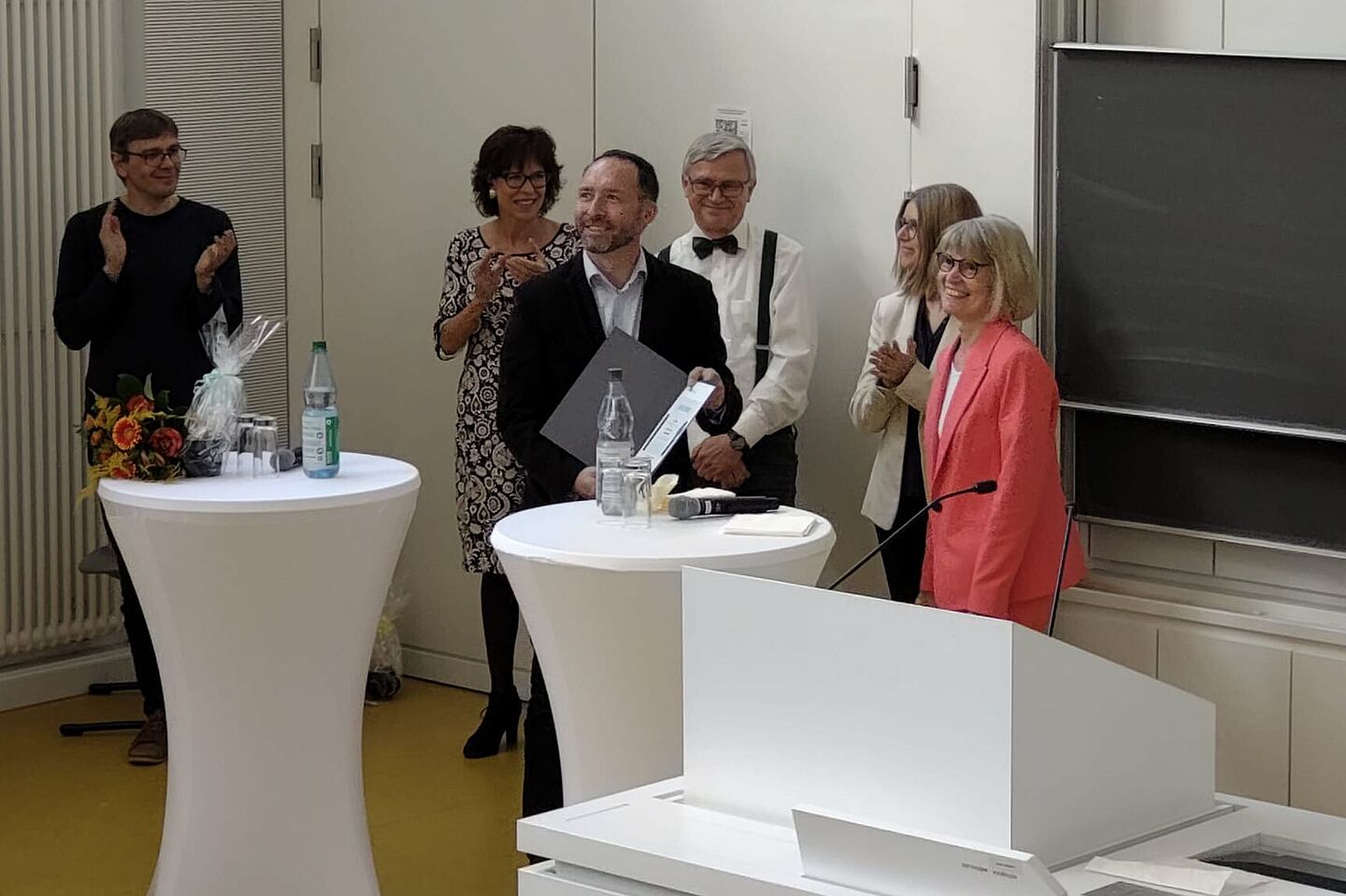Erster Lehrpreisträger Prof. Guido Reuther (Mitte). (Foto: HTWK Leipzig) Menschen an Stehtischen in Hörsaal