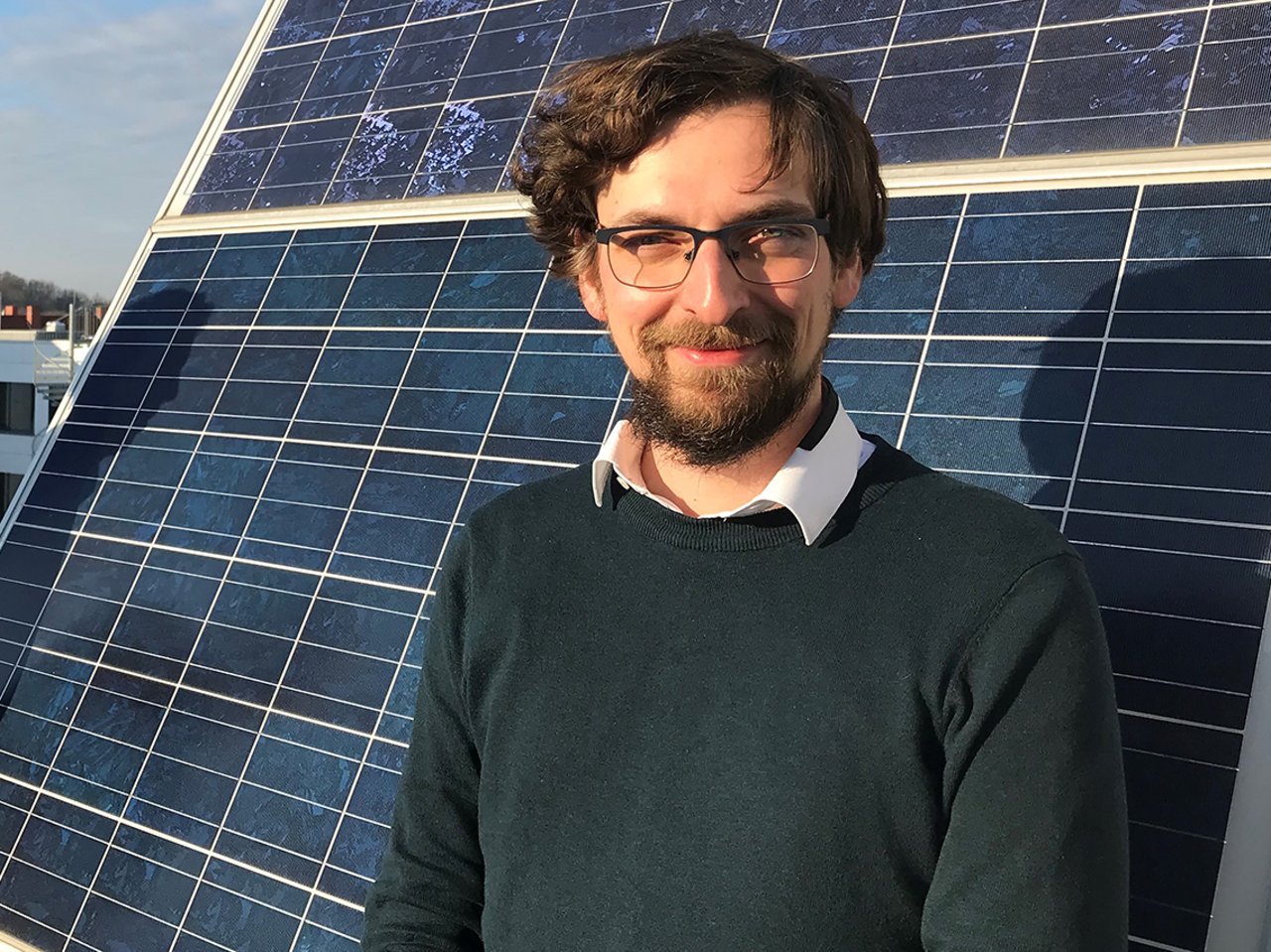 Portrait von Florian Wallburg vor einem Solarmodul