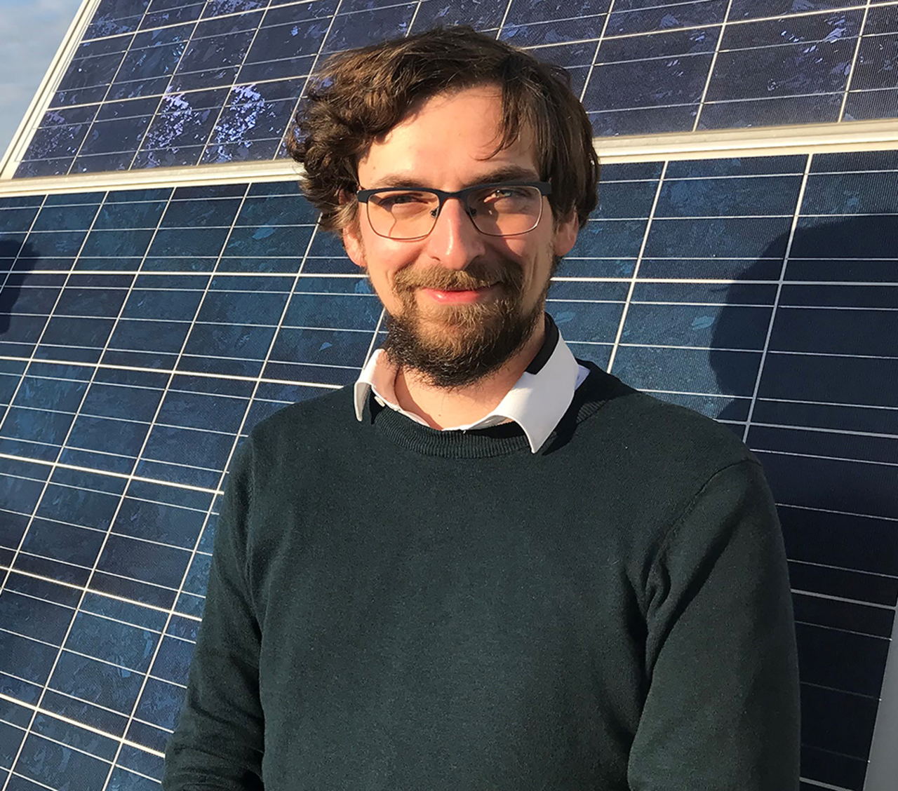 Portrait von Florian Wallburg vor einem Solarmodul