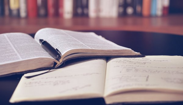Promovieren Ein Buch und ein Notizheft liegen versetzt aufeinander