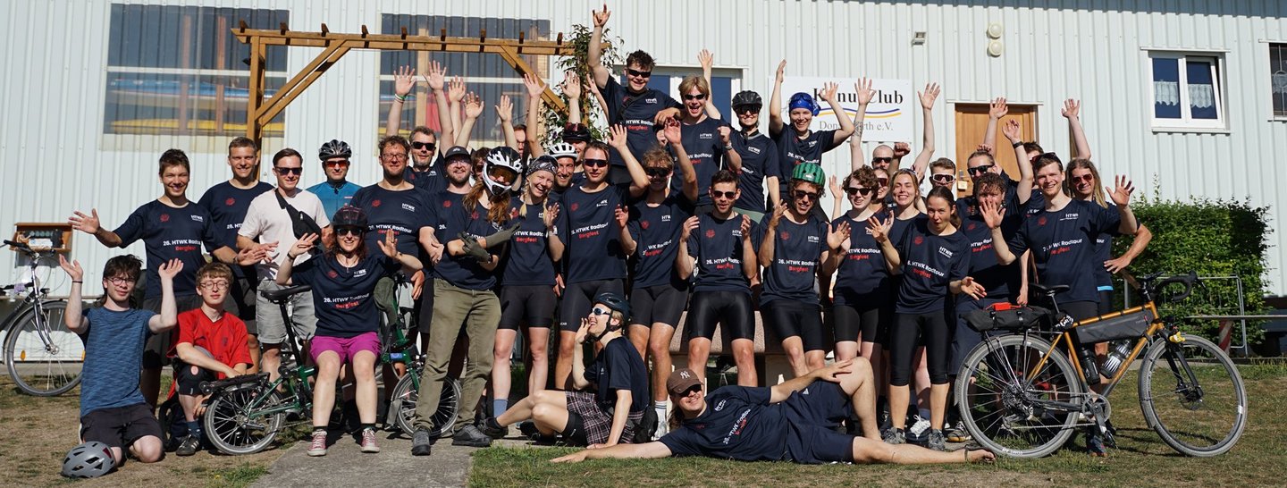 Gruppenbild mit jubelnden Teilnehmenden der Radtour, die das gemeinsame Teamshirt zur Radtour tragen.