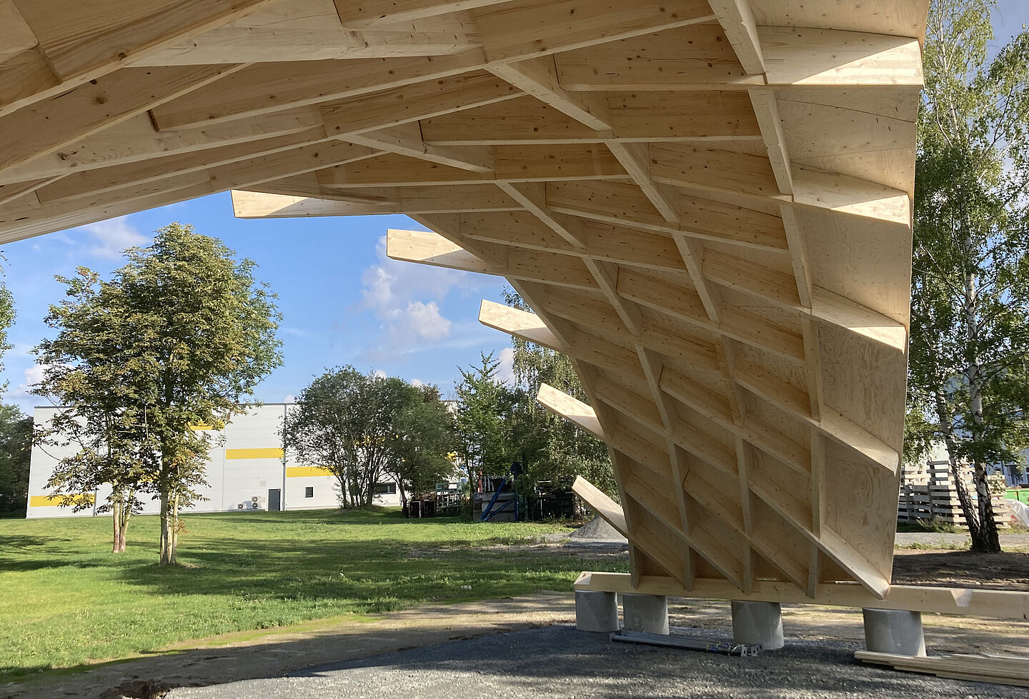 In Leipzig-Engelsdorf steht ein Demonstrator von Timber Plan Plus, ein Nachfolgemodell des Zollingerdachs, auf einer Wiese.