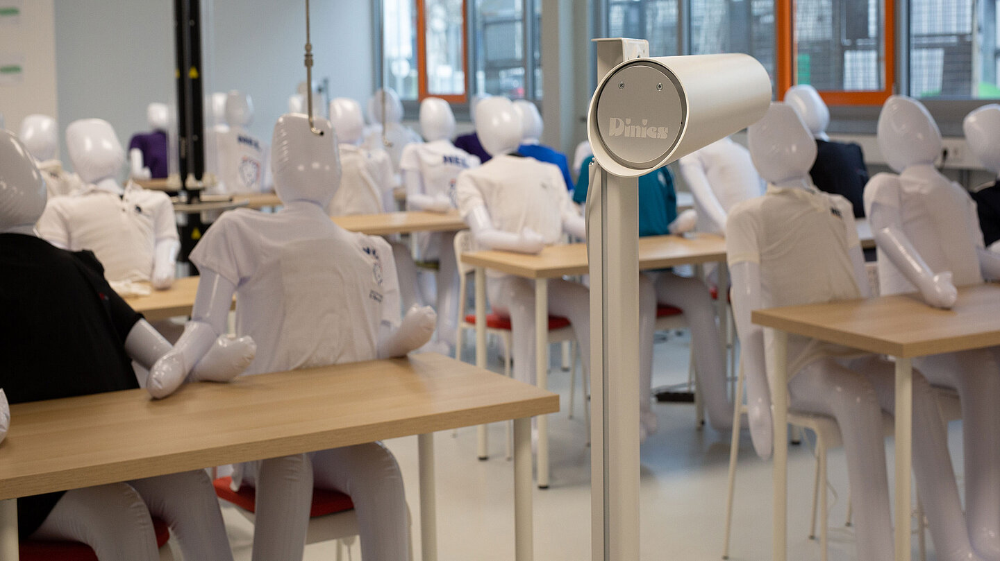 Klassenzimmer-Reallabor In einem Klassenraum sitzen aufblasbare Puppen mit T-Shirts an Tischen