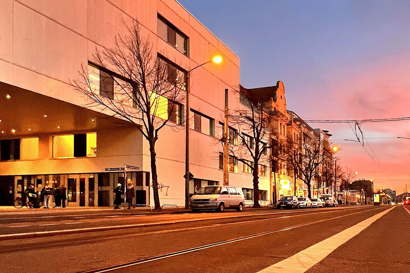 Gebäudereihe mit der Hochschulbibliothek entlang der Straße im Abendrot