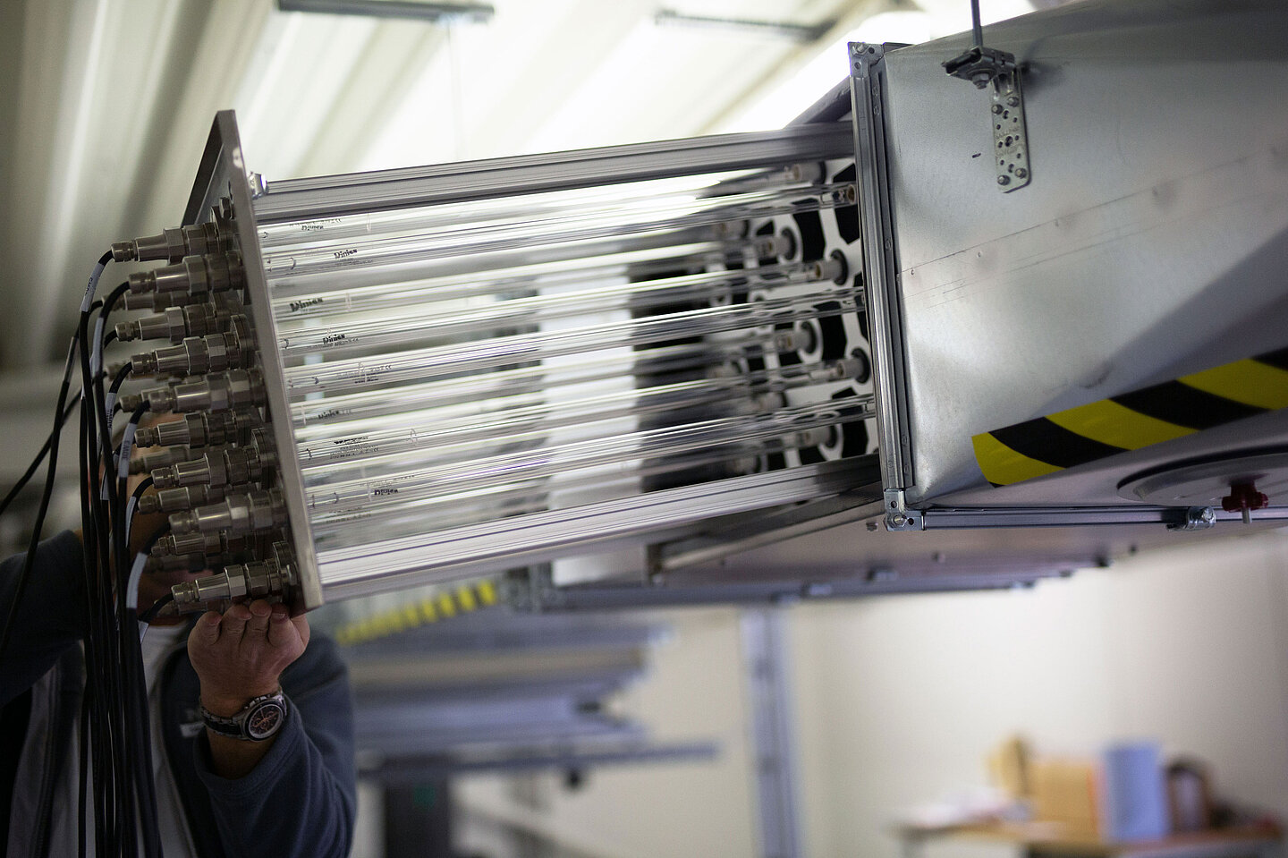 Lüftungsanlage Ein Mann montiert UVC-Strahler in eine Lüftungsanlage