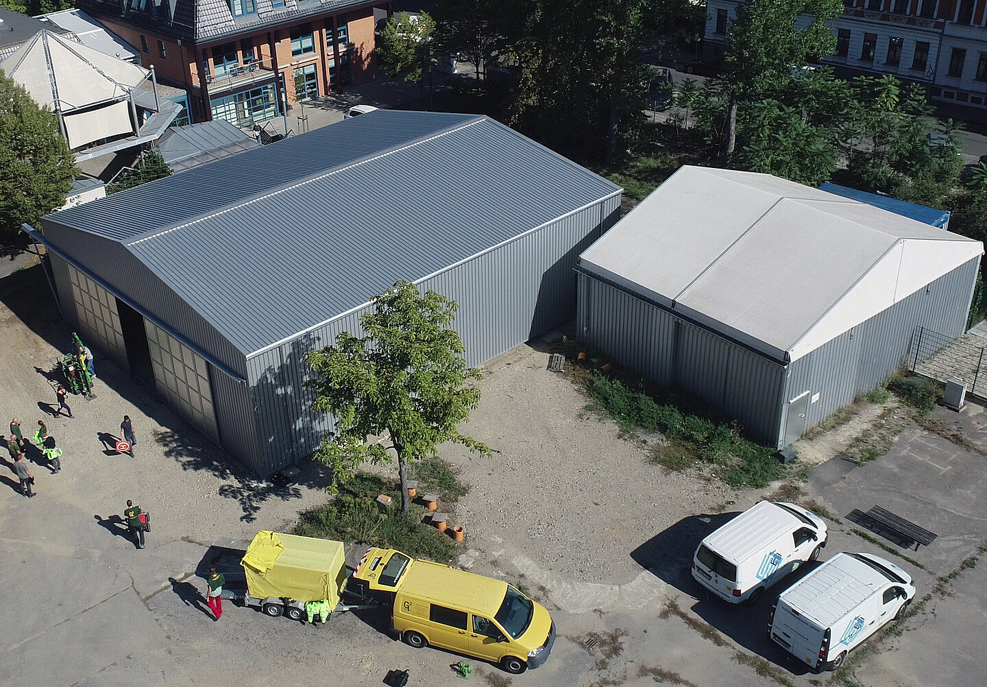 Die Luftaufnahme zeigt eine große Halle links und eine kleinere rechts daneben.