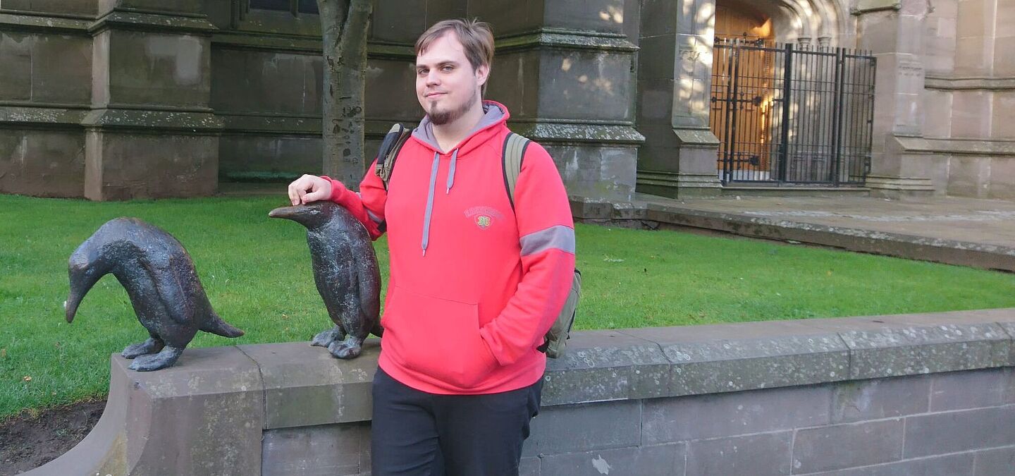 Aron Schaub mit Pinguin-Skulpturen vor einer Kirche