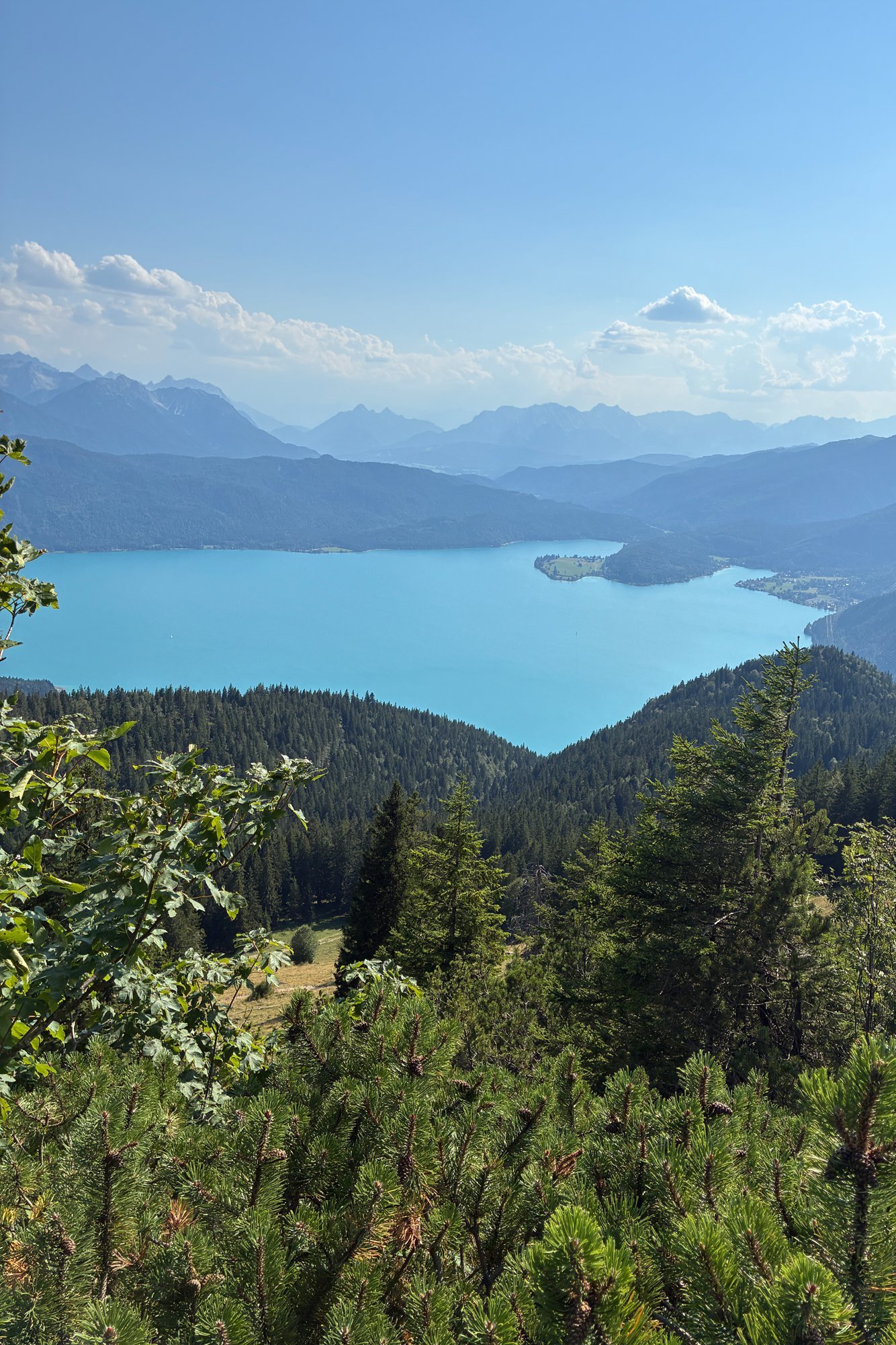 Landschaftsaufnahme von einem See umringt von Bergen.