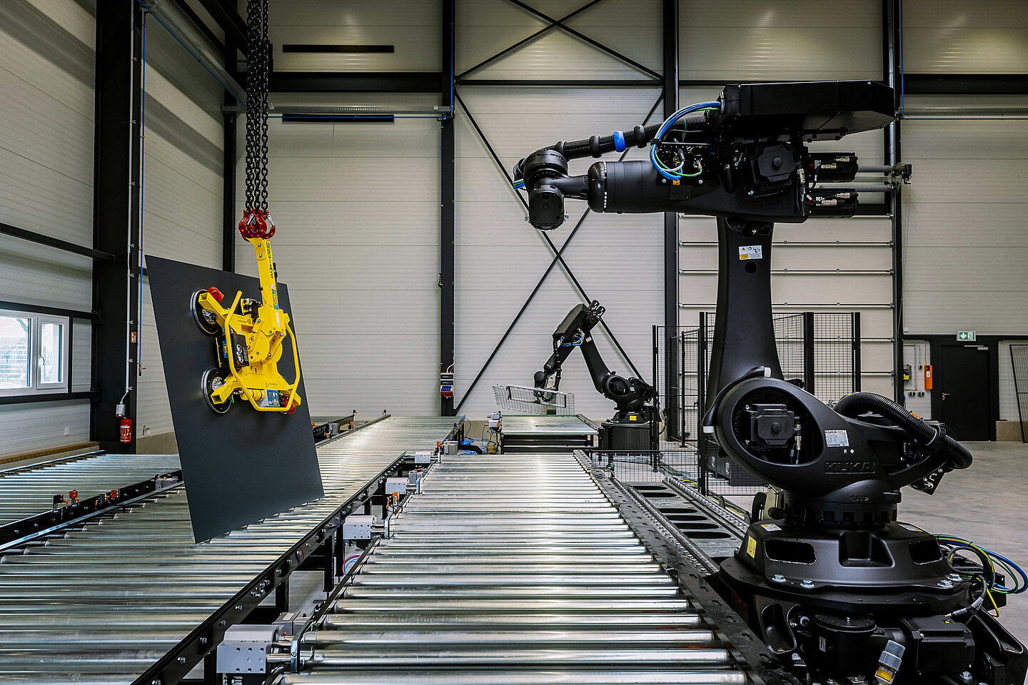 Werkhalle mit zwei Roboterarmen und einem Rollband zur Herstellung von Carbonbeton