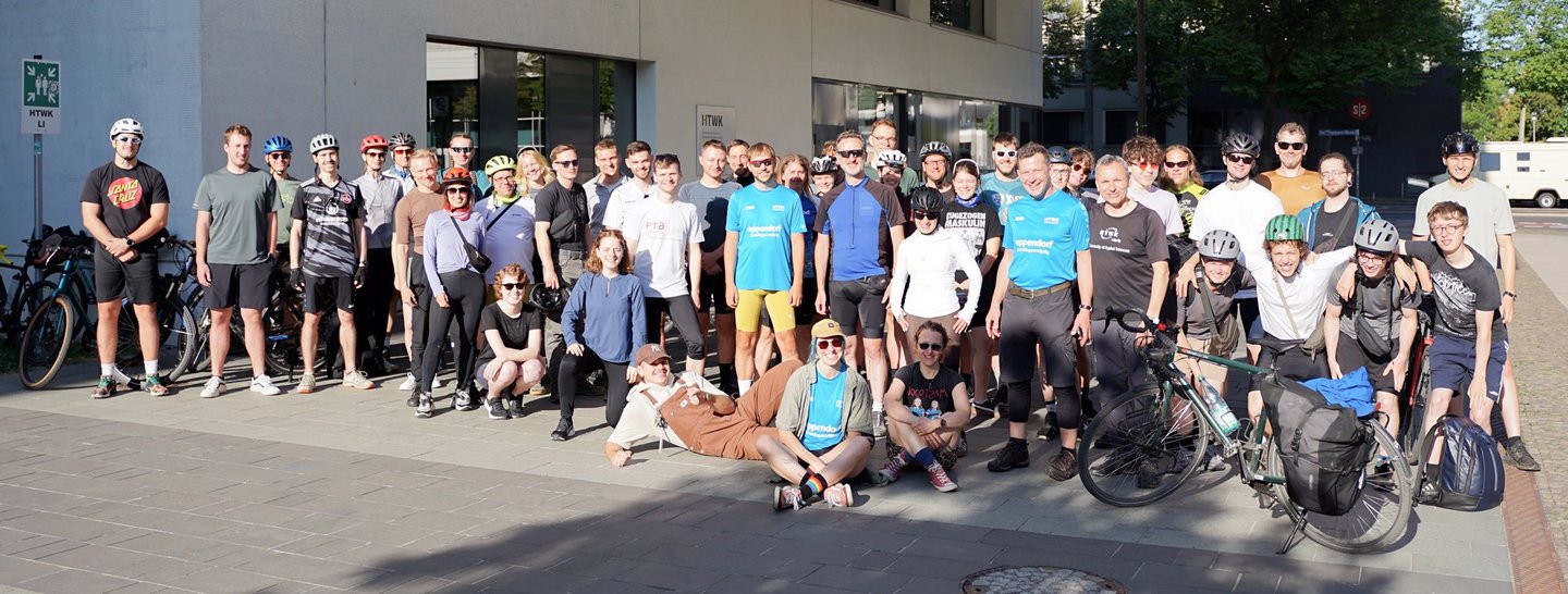 Fröhliches Gruppenbild der Teilnehmenden der Radtour neben der HTWK-Hochschulbibliothek.