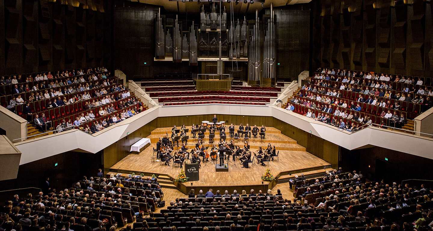 Blick von den obersten Rängen auf die Bühne mit dem spielenden Orchesters