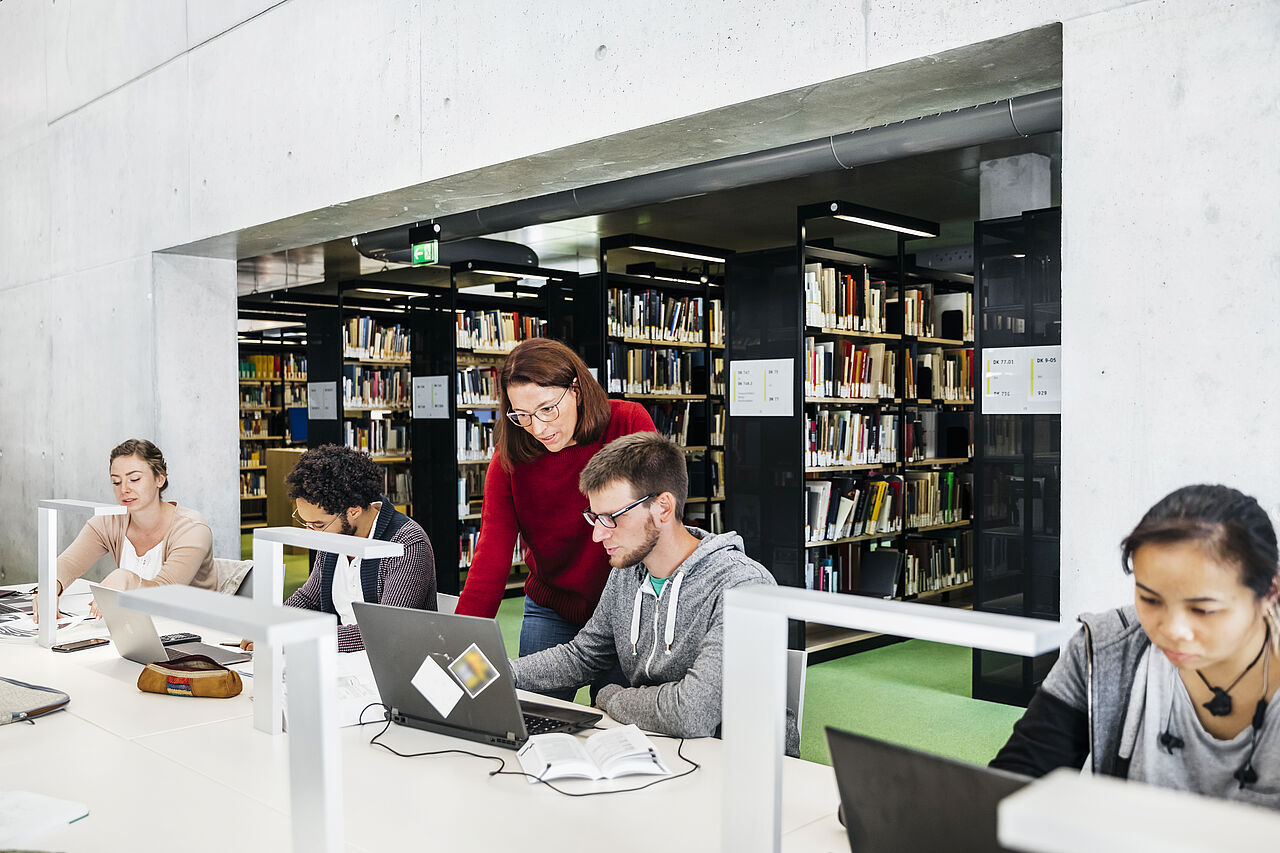 Studierende arbeiten in der Bibliothek am Laptop