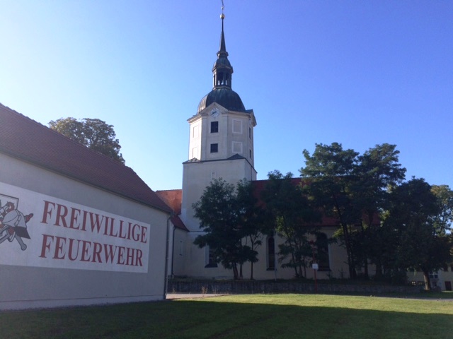 Blick vom Rathaus zur Kirche in Brandis im Sonnenschein.